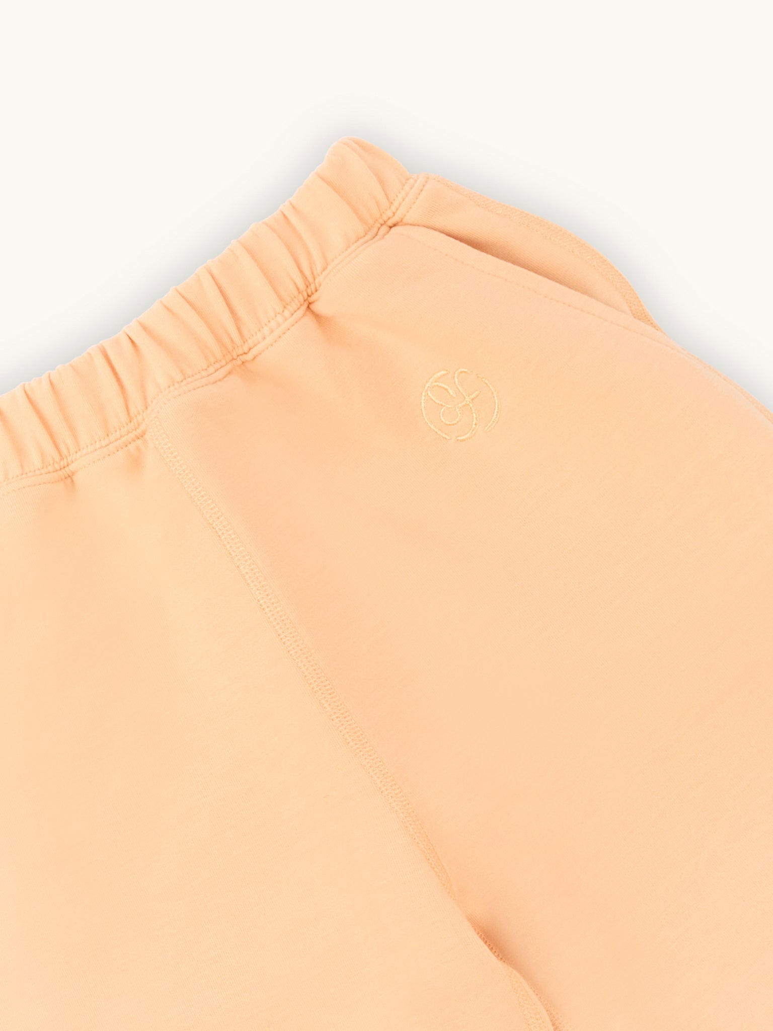 close up of farren logo on apricot kids joggers