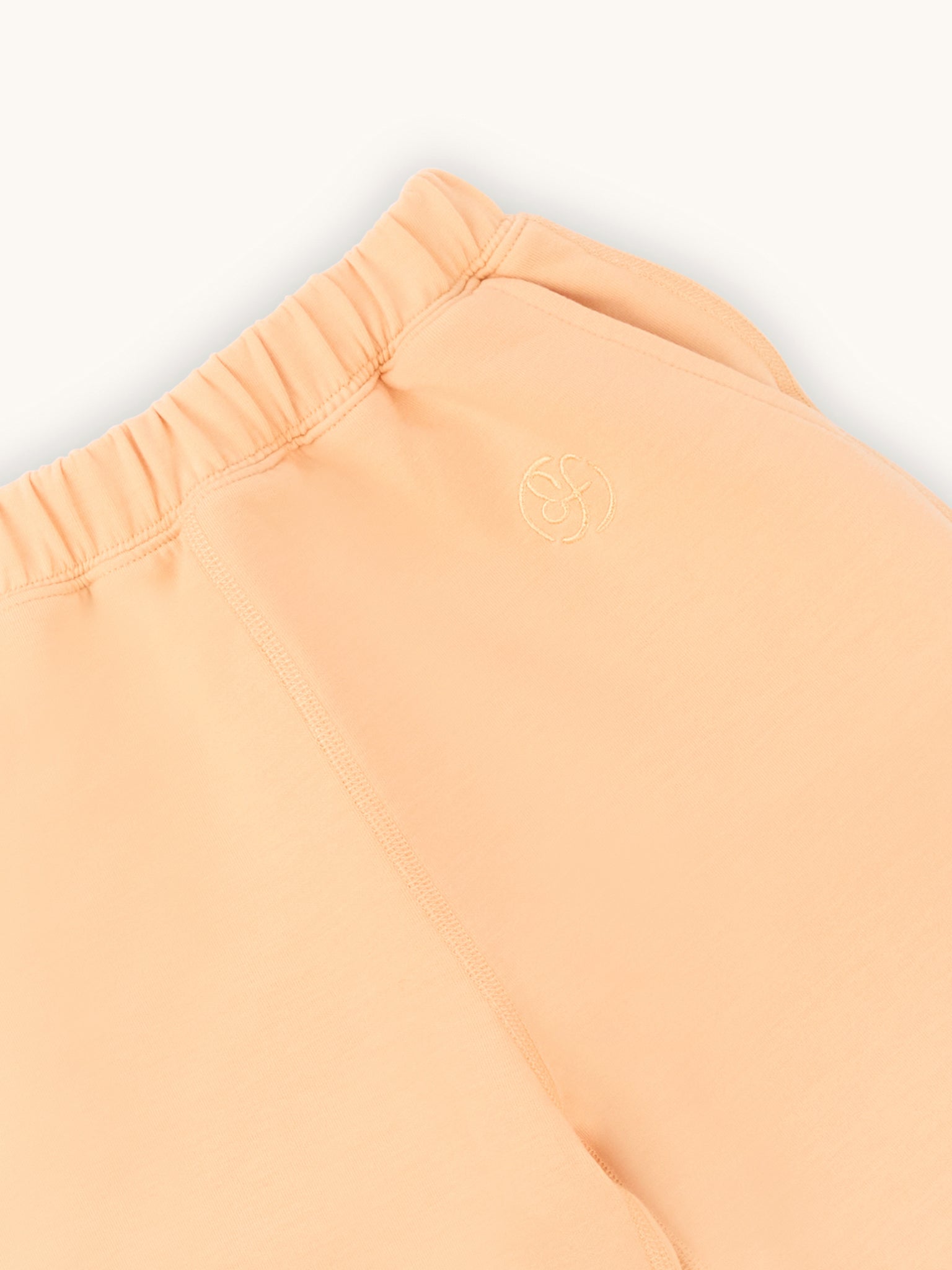 close up of  farren logo on apricot kids joggers 