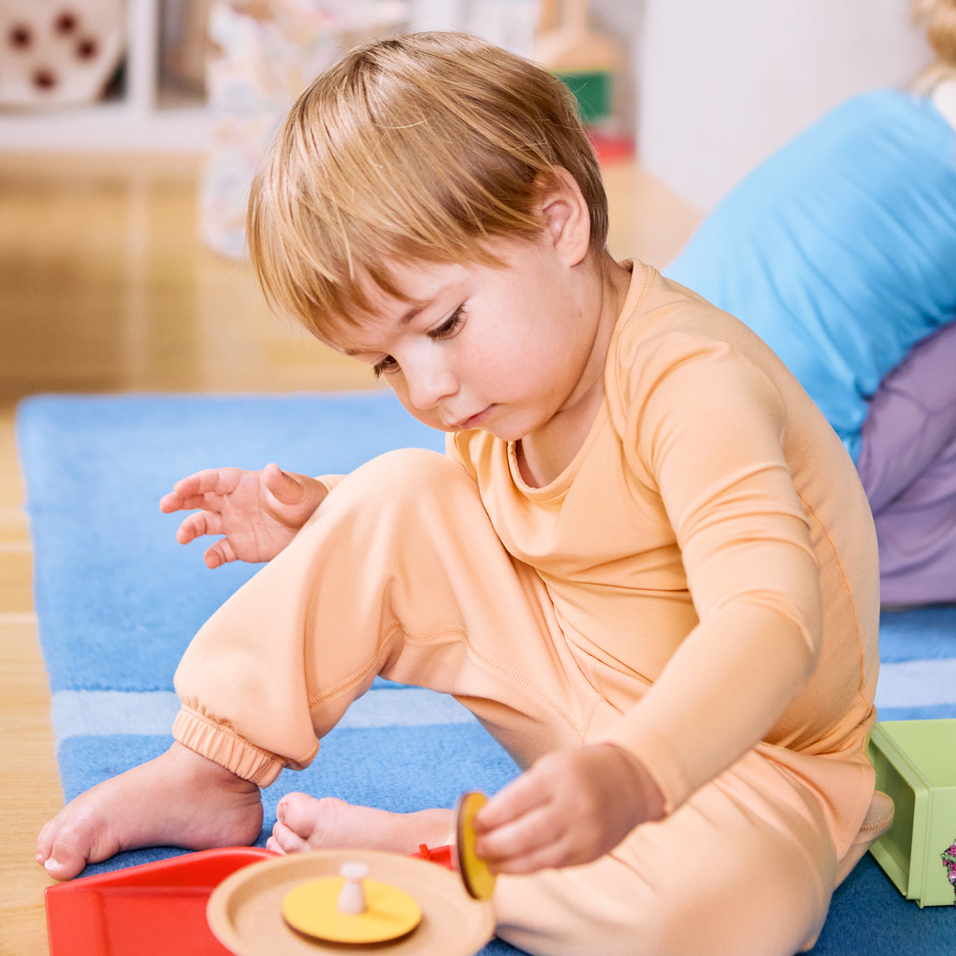 Kid playing while wearing a long sleeve kids t-shirt and joggers in apricot color