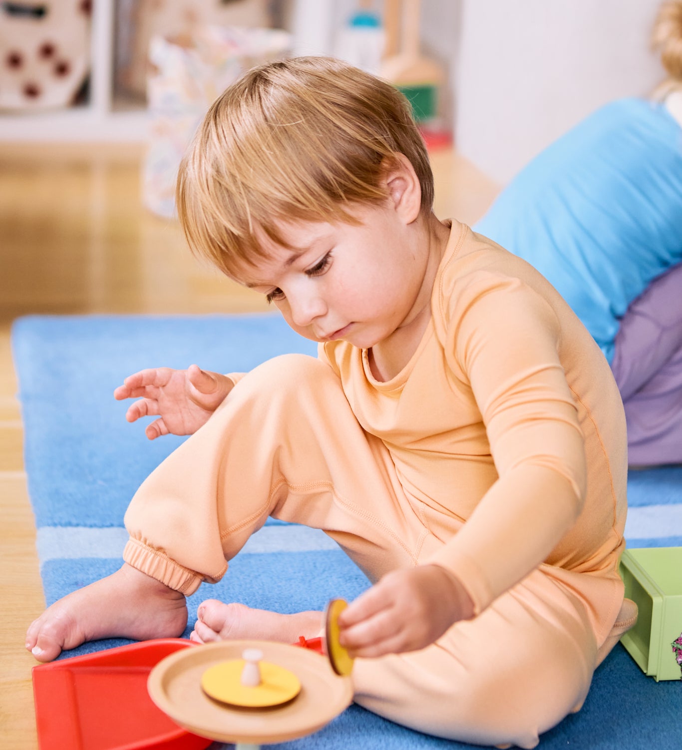 Kid playing while wearing a long sleeve kids t-shirt and joggers in apricot color