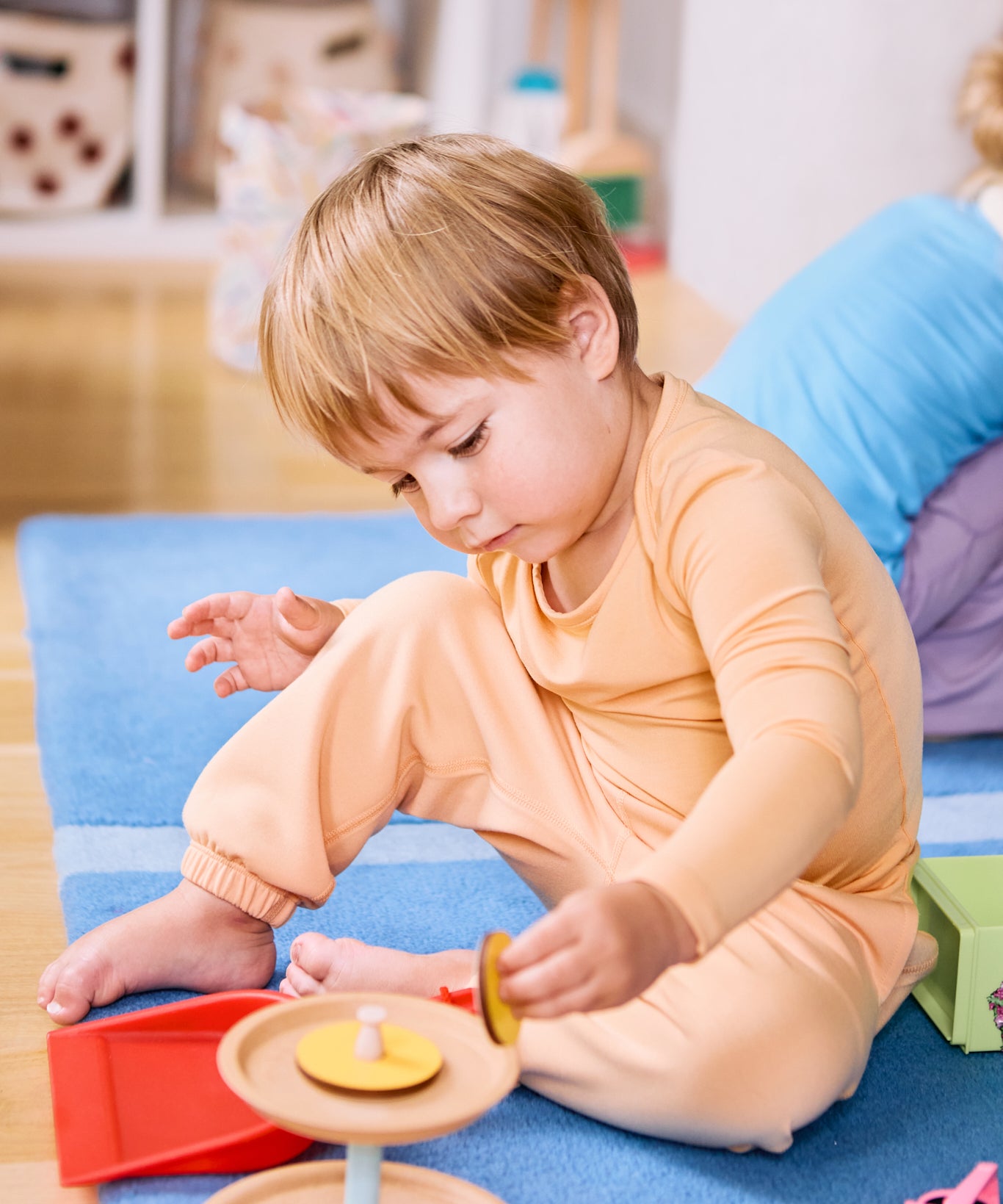 Kid playing while wearing a long sleeve kids t-shirt and joggers in apricot color