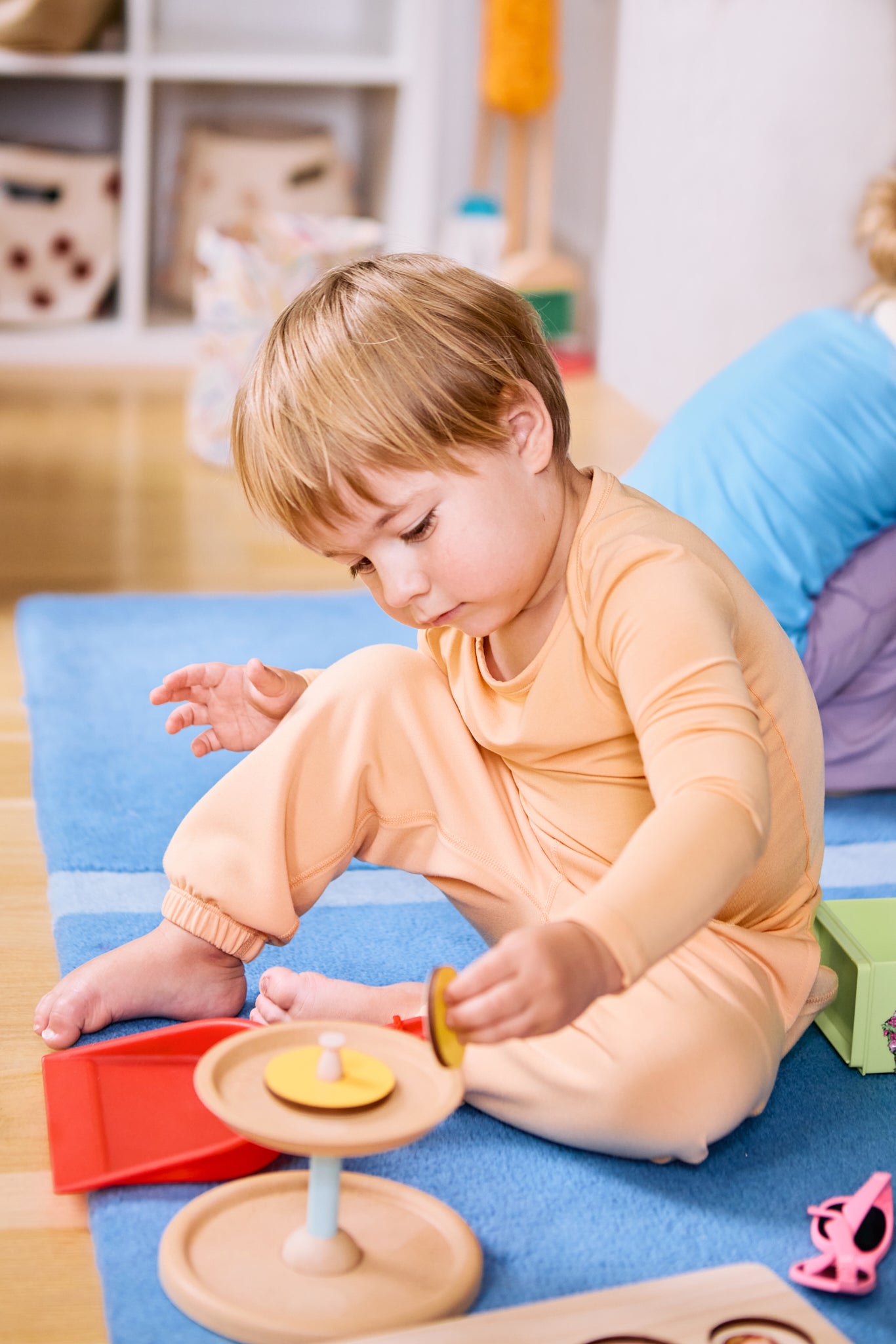 Kid playing while wearing a long sleeve kids t-shirt and joggers in apricot color