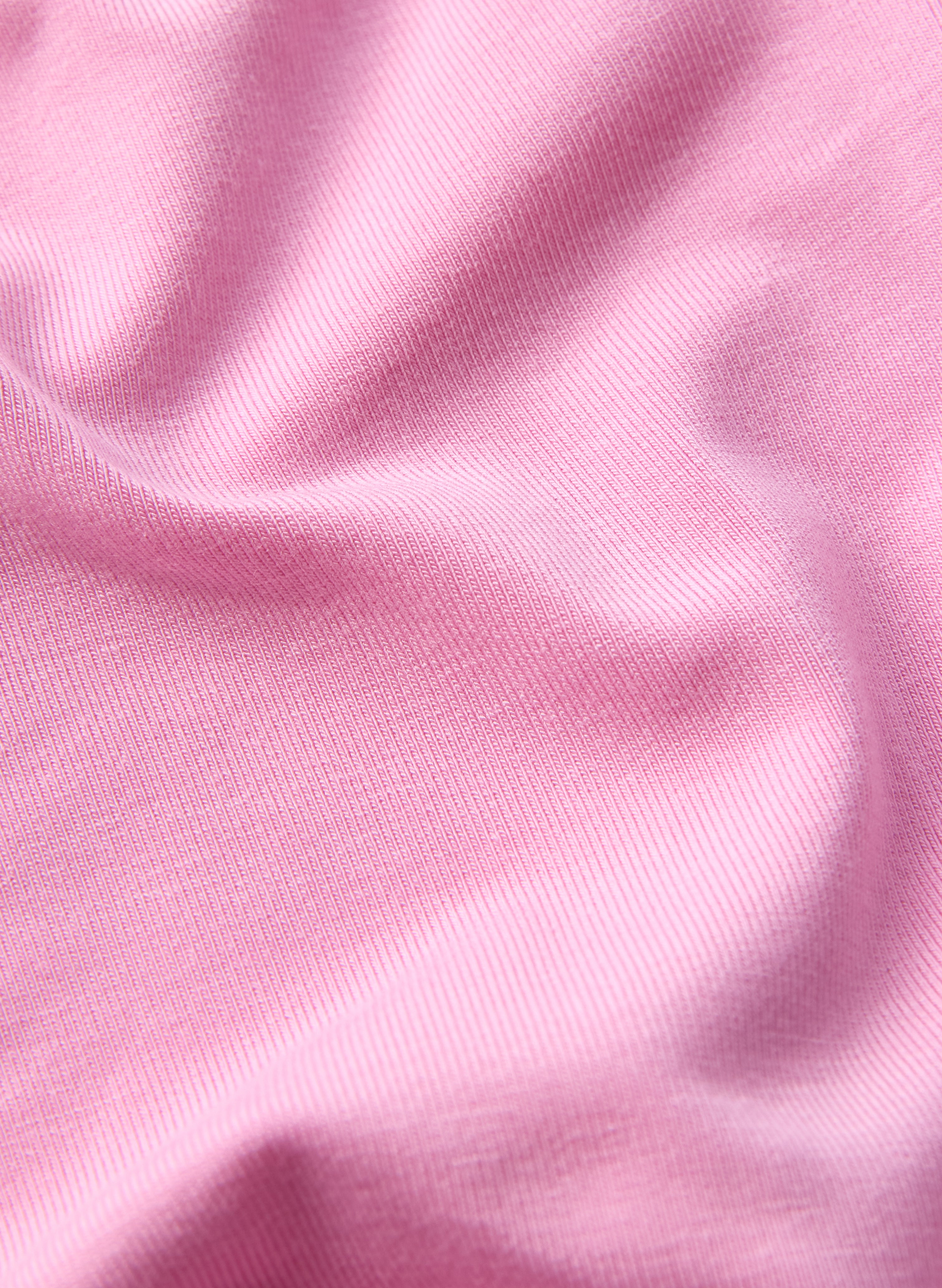 Zoomed-in view of the material of a long sleeve onesie in lotus pink color.